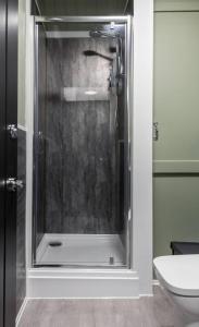 a glass shower in a bathroom with a toilet at Caledonia Suite by The Wallace Monument in Stirling +14 photos