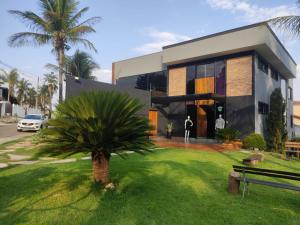 a house with a palm tree in front of it at jaó, mazzahome in Goiânia