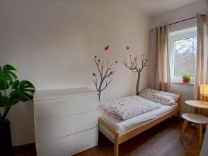 a bedroom with a bed with birds on the wall at Haus am Seidelberg in Dürrhennersdorf