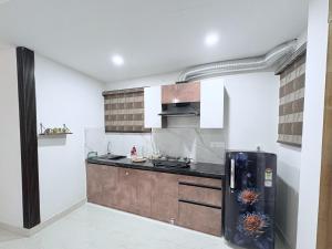 a kitchen with a black refrigerator in a room at B&A Stays in Dehradun