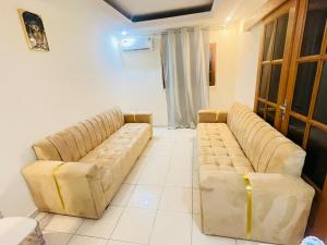 a living room with two leather couches in a room at Bulle d'Or Serenity in Libreville