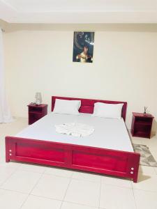 a bedroom with a large bed with a red frame at Bulle d'Or Serenity in Libreville