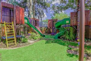a playground with a green slide in a yard at Afrique Boutique Hotel O.R. Tambo in Boksburg