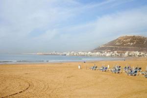 a beach with a bunch of chairs and the ocean at Nawal's guest house in Tadouart