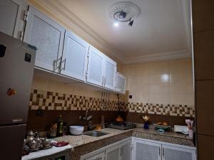 a kitchen with white cabinets and a sink at Nawal's guest house in Tadouart +102 photos