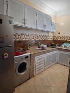 a kitchen with a refrigerator and a washing machine at Nawal's guest house in Tadouart