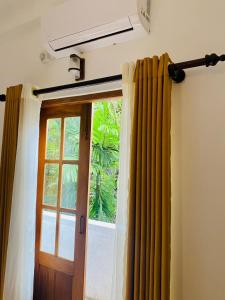 a room with a door and a window with curtains at New Arverne Villa Kandy in Kandy