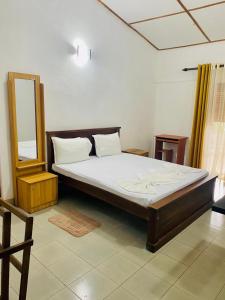 a large bed in a room with a mirror at New Arverne Villa Kandy in Kandy