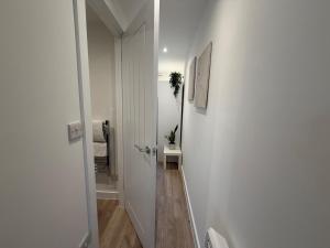 a hallway with a white door leading to a bathroom at Rosewell Lower Dicker in Horsebridge +15 photos