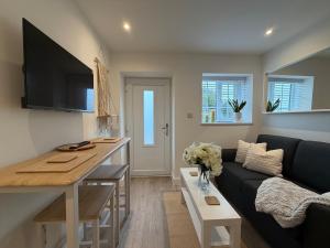 a living room with a couch and a table at Rosewell Lower Dicker in Horsebridge