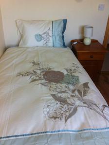 - un lit avec une couverture fleurie dans l'établissement Kilmore Quay Castleview 1 - 5 Bedroom House, à Kilmore Quay