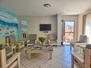 a living room with chairs and a table and a tv at Vitamiene-See Hartenbos in Hartenbos