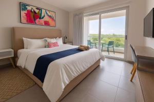 a bedroom with a large bed and a table at Steps from 5th Ave with Rooftop Pool Gym & Cinema in Playa del Carmen