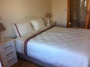 a bedroom with a large bed with white sheets and pillows at Kilmore Quay Castleview 1 - 5 Bedroom House in Kilmore Quay