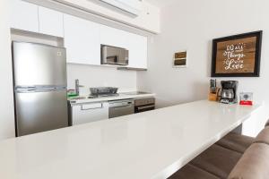 a kitchen with a white counter top and a refrigerator at Steps from 5th Ave with Rooftop Pool Gym & Cinema in Playa del Carmen