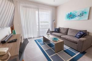 a living room with a couch and a table at Steps from 5th Ave with Rooftop Pool Gym & Cinema in Playa del Carmen +22 photos