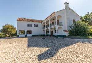 a large white house with a brick driveway at Quinta Vale Leitão in Coimbra