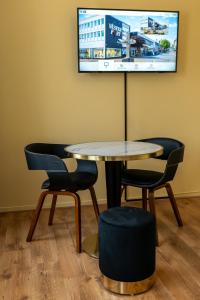 a table and chairs with a tv on the wall at Hotell Navet in Västervik