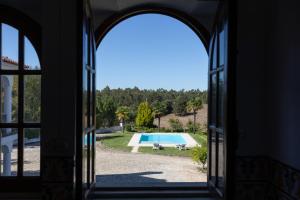 a view of a pool through an open window at Quinta Vale Leitão in Coimbra
