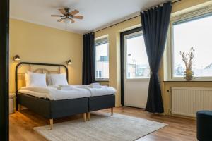 a bedroom with a bed and two windows at Hotell Navet in Västervik