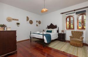 a bedroom with a bed and a chair in it at Quinta Vale Leitão in Coimbra