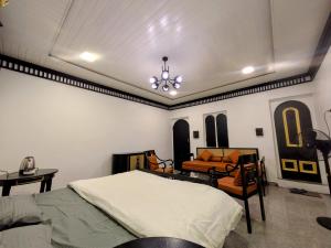 a bedroom with a bed and a couch and a chandelier at Nomada in Mount Ābu