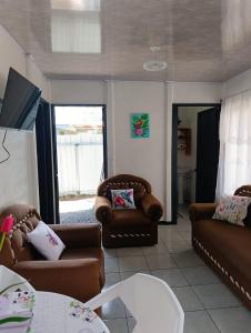 a living room with two couches and a tv at Casa Mariposa Full Accommodation in Sabalito