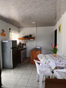 a kitchen with a table and a refrigerator at Casa Mariposa Full Accommodation in Sabalito
