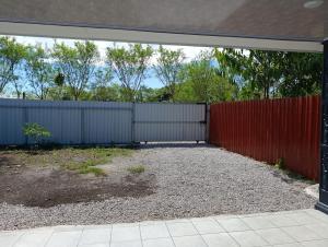 an empty backyard with a red fence at Casa Mariposa Full Accommodation in Sabalito