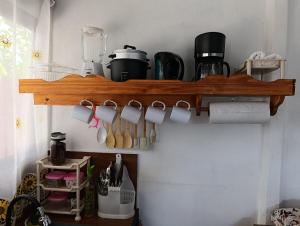 a wooden shelf with cups and utensils on it at Casa Mariposa Full Accommodation in Sabalito +4 photos