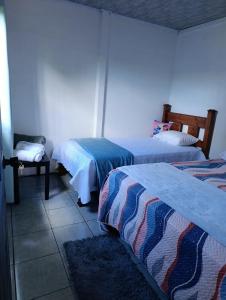 a room with two beds and a table and a room with two beds at Casa Mariposa Full Accommodation in Sabalito