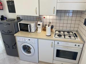 a kitchen with a stove microwave and a washer at 20 a Trieste in Trieste
