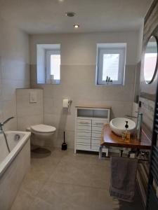 a bathroom with a tub and a sink and a toilet at Haus am Seidelberg in Dürrhennersdorf +46 photos