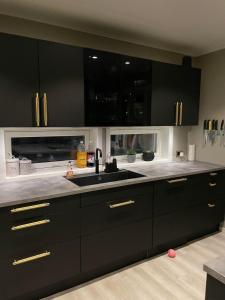 a kitchen with black cabinets and a sink at Villa Aurora in Alta