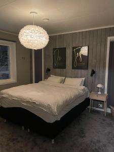 a bedroom with a large bed and a chandelier at Villa Aurora in Alta
