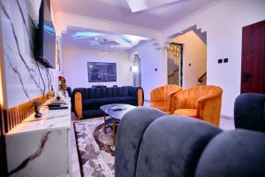 a living room with a blue couch and chairs at The Vistana 4Bedroom Pearly Gate Estate Ikota VGC Lekki in Igboshere