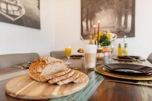 a table with a loaf of bread on a cutting board at Burgberg City Apartment in Daun