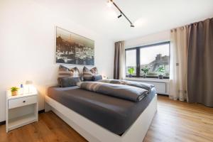 a bedroom with a large bed and a large window at Burgberg City Apartment in Daun +24 photos