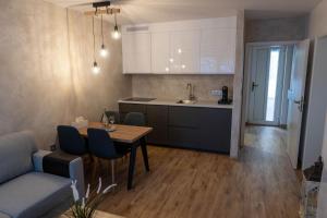 a kitchen and living room with a table and a couch at Apartmán u Pivovaru in Rožnov pod Radhoštěm