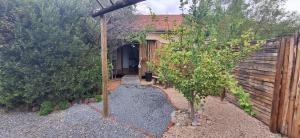 a backyard with a wooden fence and a tree at Mitat Guesthouse in Beaufort West