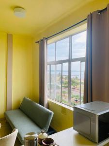 a room with a window with a couch and a television at Frontline Holiday apartment in Durban