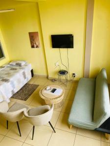 a room with a bed and a couch and a tv at Frontline Holiday apartment in Durban