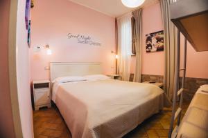 a bedroom with a bed and a sign on the wall at Locanda Del Picchio in Loreto