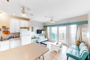a kitchen with a couch and a table in a room at Oceanfront, dog-friendly condo with ocean view, pool & central AC in Hatteras