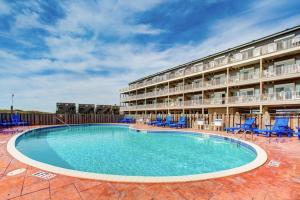 a large swimming pool in front of a hotel at Oceanfront, dog-friendly condo with ocean view, pool & central AC in Hatteras