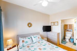 a bedroom with a bed and a tv on the wall at Oceanfront, dog-friendly condo with ocean view, pool & central AC in Hatteras +17 photos