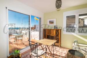 a room with a table and chairs and a balcony at Casa Nana Townhouse with seaview in Torrox