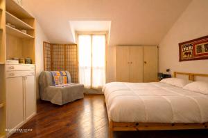 a bedroom with a bed and a chair and a window at The Central Milano in Milan