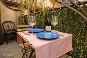 a table with two glasses and a bottle of wine at The Central Milano in Milan