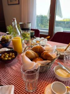 a table with a plate of bread and orange juice at Alps and Lakeview Villa with Pool in Haut-Vully